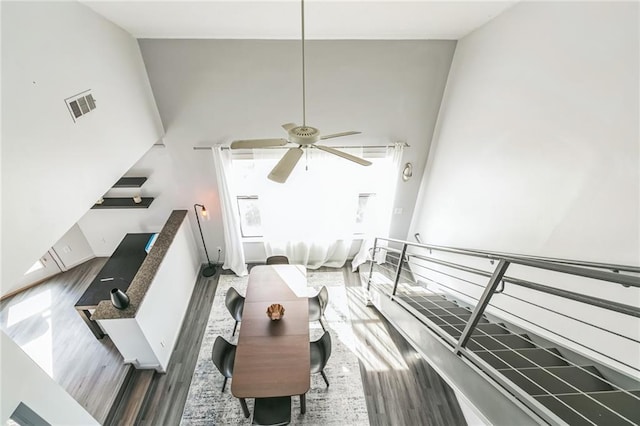 living room with ceiling fan, high vaulted ceiling, a wealth of natural light, and hardwood / wood-style floors