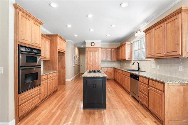 kitchen featuring a center island, light stone counters, ornamental molding, and stainless steel appliances