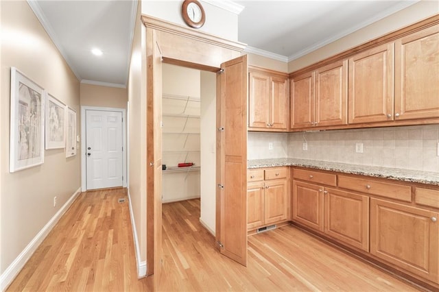 kitchen featuring light stone countertops, light wood-type flooring, ornamental molding, and backsplash