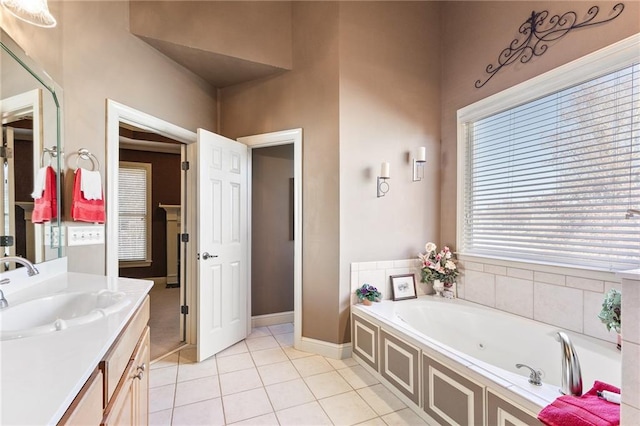 bathroom with tile patterned floors, vanity, and a tub to relax in