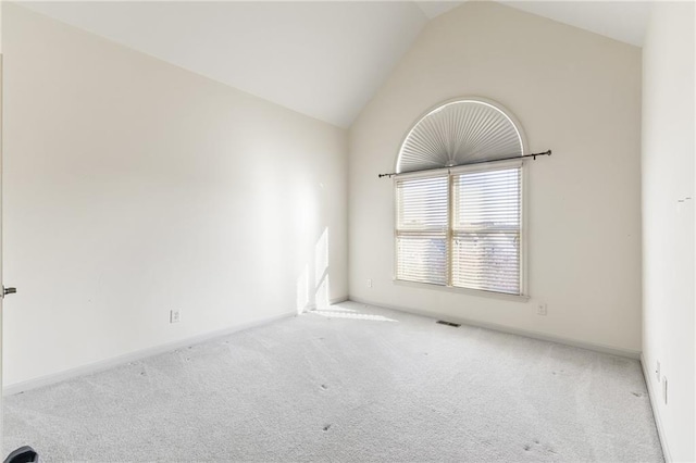 carpeted spare room featuring vaulted ceiling