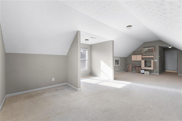 bonus room featuring light colored carpet, a textured ceiling, and vaulted ceiling