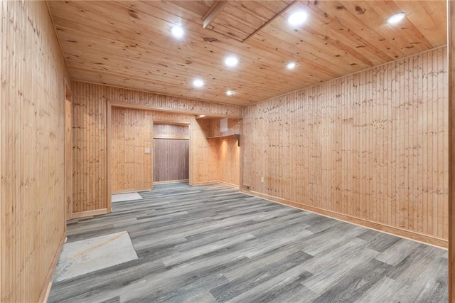 spare room with wood walls, wooden ceiling, and light hardwood / wood-style flooring