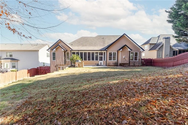 back of house with a sunroom and a yard