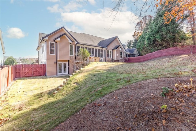 back of property featuring french doors, a yard, and a sunroom