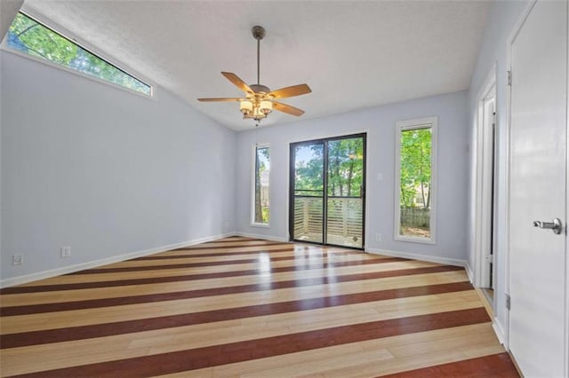 unfurnished room featuring light wood-type flooring, vaulted ceiling, and ceiling fan