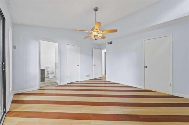 unfurnished bedroom with ceiling fan, wood-type flooring, and ensuite bathroom