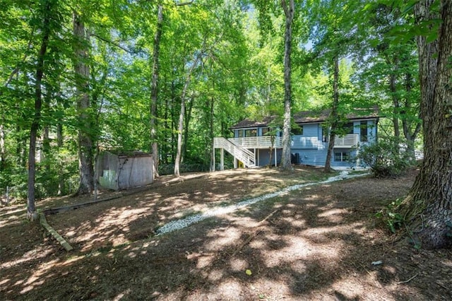 rear view of house featuring a storage unit and a deck