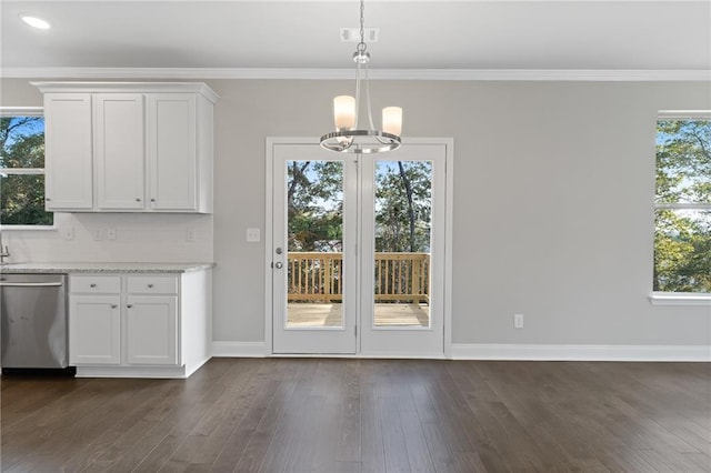 unfurnished dining area with dark wood-type flooring, ornamental molding, and a notable chandelier