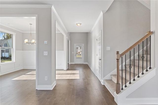 entryway featuring crown molding, dark hardwood / wood-style floors, and a chandelier