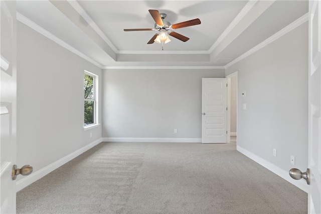 empty room featuring crown molding, carpet flooring, a tray ceiling, and ceiling fan