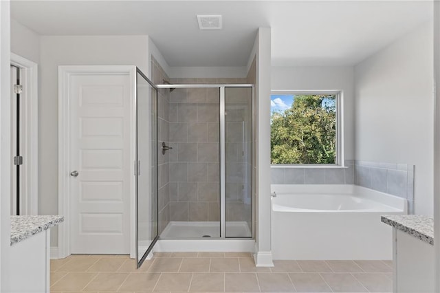 bathroom featuring vanity, tile patterned floors, and plus walk in shower