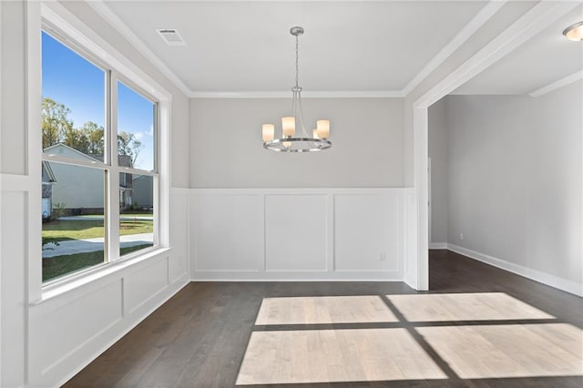 unfurnished dining area with ornamental molding, dark hardwood / wood-style floors, a wealth of natural light, and a chandelier