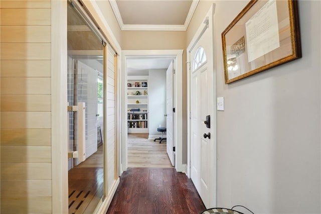 entryway featuring built in shelves, wood-type flooring, plenty of natural light, and ornamental molding