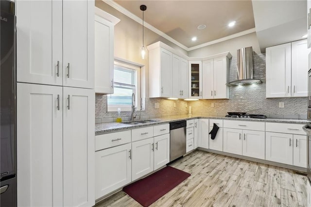 kitchen with light stone countertops, stainless steel appliances, white cabinets, and wall chimney range hood