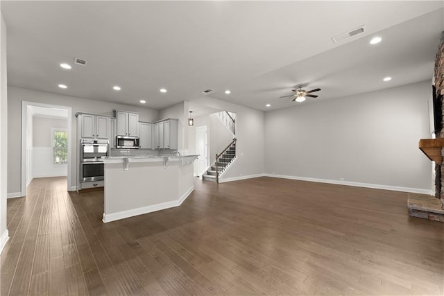 427 Dawson Pointe Pkwy, Dawsonville, GA 30534 - kitchen with stainless steel appliances, a kitchen bar, dark wood-style floors, ceiling fan, and recessed lighting