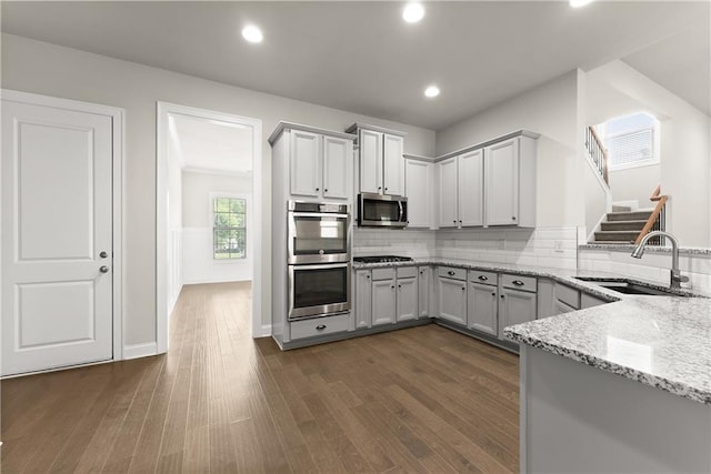 427 Dawson Pointe Pkwy, Dawsonville, GA 30534 - kitchen featuring appliances with stainless steel finishes, a sink, light stone countertops, dark wood finished floors, and backsplash