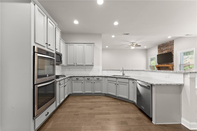 427 Dawson Pointe Pkwy, Dawsonville, GA 30534 - kitchen featuring stainless steel appliances, a sink, a peninsula, wood finished floors, and ceiling fan