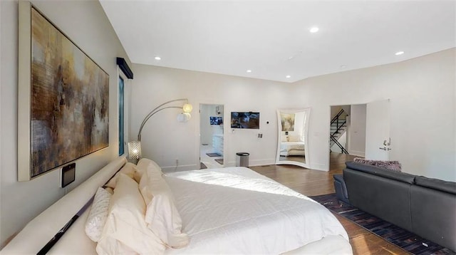 bedroom with baseboards, wood finished floors, and recessed lighting