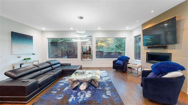 living area with baseboards, a fireplace, wood finished floors, and recessed lighting