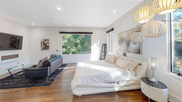 bedroom with baseboards, wood finished floors, and recessed lighting