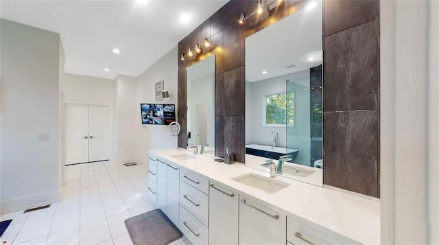 full bathroom featuring tile patterned flooring, a freestanding tub, a sink, and an enclosed shower