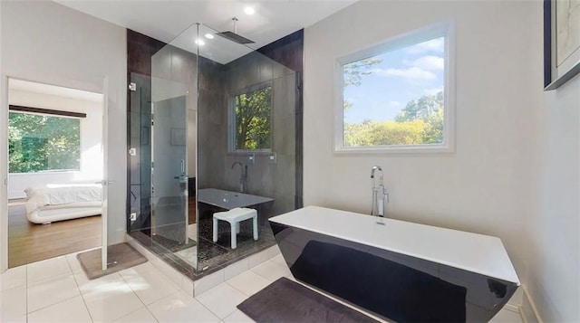 full bath featuring plenty of natural light, a stall shower, tile patterned flooring, and connected bathroom