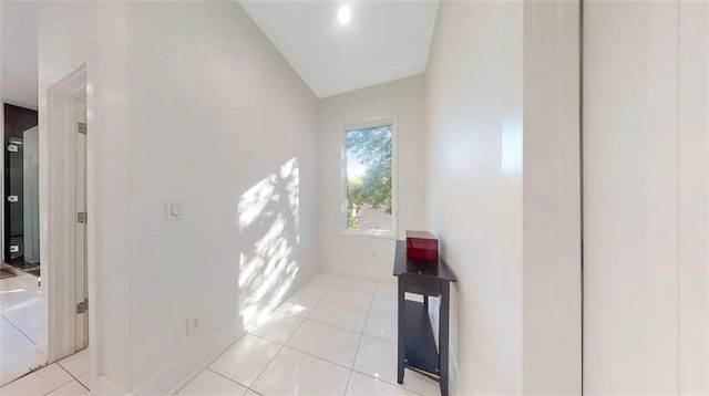 hall featuring light tile patterned floors and baseboards