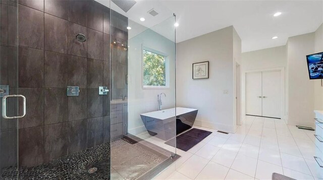 bathroom with visible vents, a freestanding bath, a shower stall, and tile patterned floors