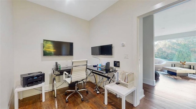 office space featuring vaulted ceiling, baseboards, and wood finished floors