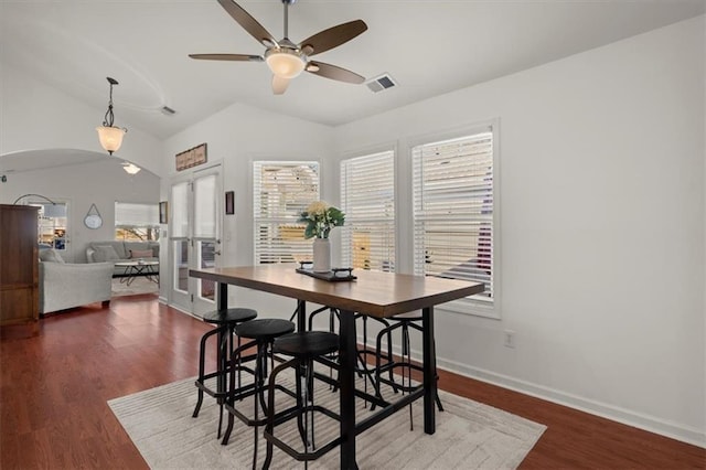 dining room with ceiling fan, lofted ceiling, and dark wood-type flooring