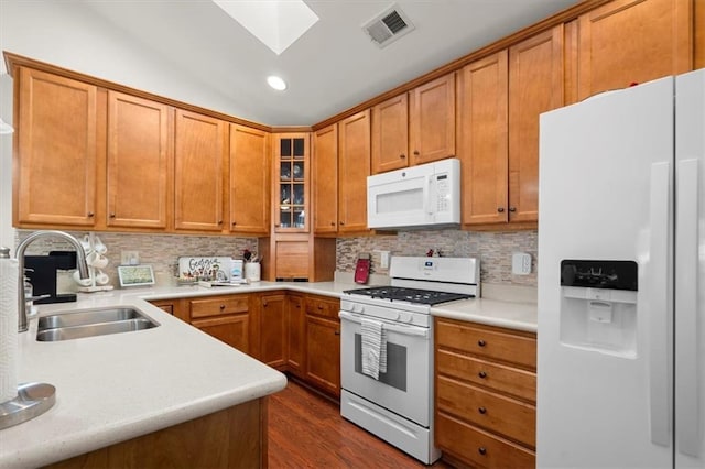 kitchen with tasteful backsplash, sink, dark hardwood / wood-style floors, and white appliances