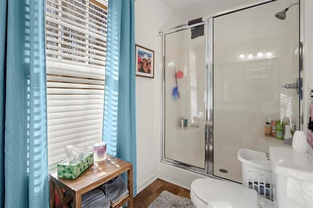 bathroom with tile patterned floors, toilet, and an enclosed shower