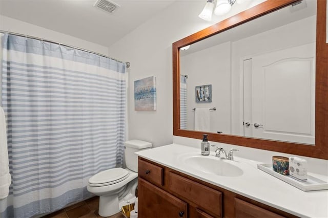 bathroom with tile patterned flooring, vanity, toilet, and walk in shower