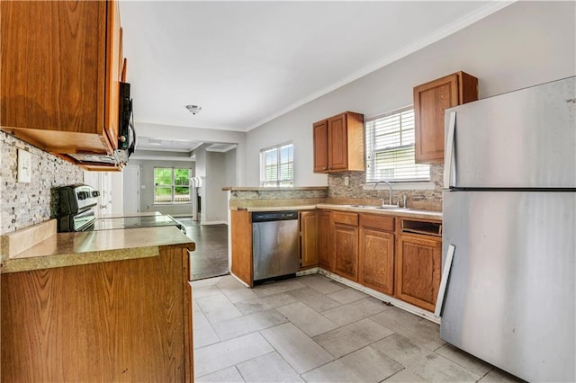 2005 Chicago Ave NW, Atlanta, GA 30314 - kitchen featuring stainless steel appliances, brown cabinets, decorative backsplash, ornamental molding, and light countertops