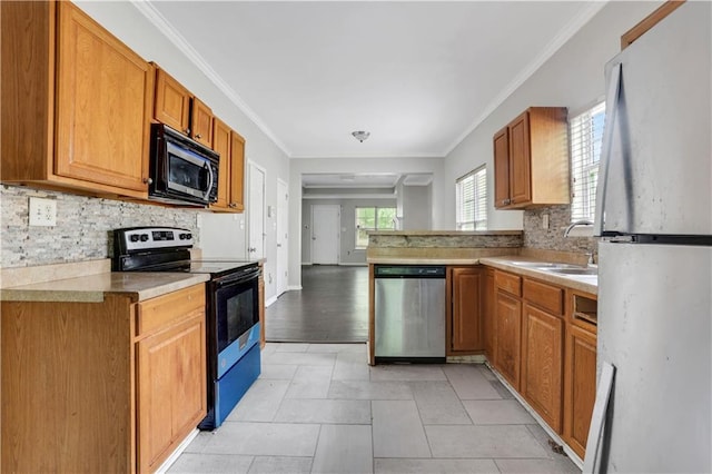 2005 Chicago Ave NW, Atlanta, GA 30314 - kitchen featuring stainless steel appliances, backsplash, crown molding, light countertops, and brown cabinets