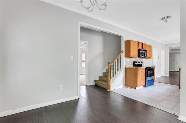 2005 Chicago Ave NW, Atlanta, GA 30314 - kitchen with electric stove, black microwave, crown molding, light countertops, and decorative backsplash