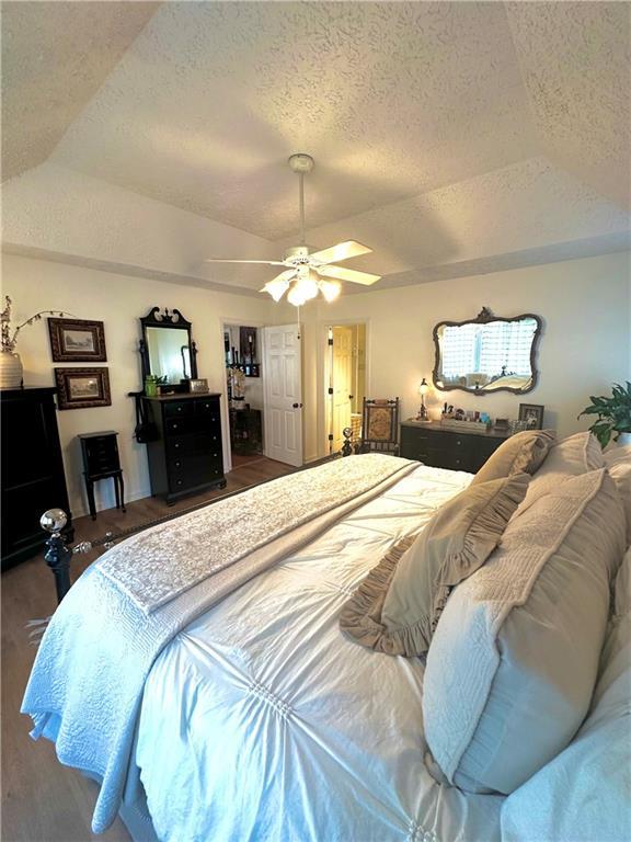 227 Bennett Farms Trl, Acworth, GA 30102 - bedroom featuring wood finished floors, vaulted ceiling, a textured ceiling, and a ceiling fan