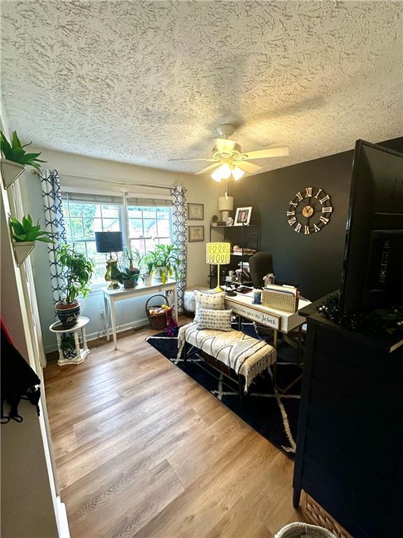 227 Bennett Farms Trl, Acworth, GA 30102 - bedroom with a textured ceiling, a desk, wood finished floors, and a ceiling fan