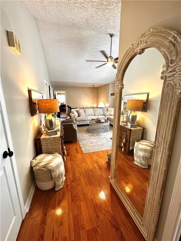 227 Bennett Farms Trl, Acworth, GA 30102 - living room with a textured ceiling, a ceiling fan, wood finished floors, and lofted ceiling