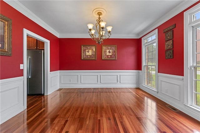 871 Windsor Creek Dr, Grayson, GA 30017 - unfurnished dining area featuring wood finished floors, a chandelier, wainscoting, and crown molding
