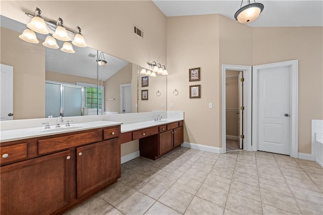 871 Windsor Creek Dr, Grayson, GA 30017 - bathroom featuring a stall shower, double vanity, vaulted ceiling, tile patterned flooring, and a walk in closet