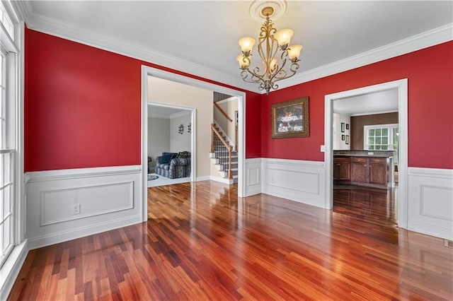 871 Windsor Creek Dr, Grayson, GA 30017 - unfurnished dining area with wood finished floors, stairs, a chandelier, a wainscoted wall, and crown molding