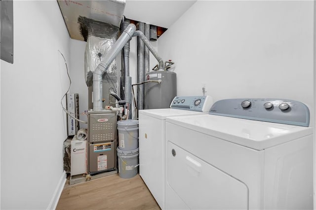 washroom with light hardwood / wood-style flooring, gas water heater, and washing machine and dryer