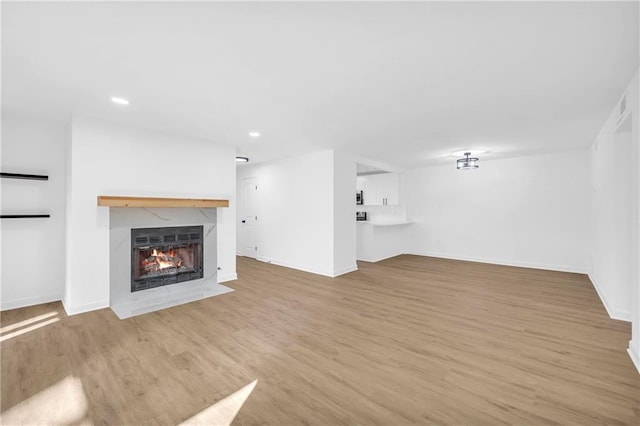 unfurnished living room with light hardwood / wood-style flooring and a premium fireplace