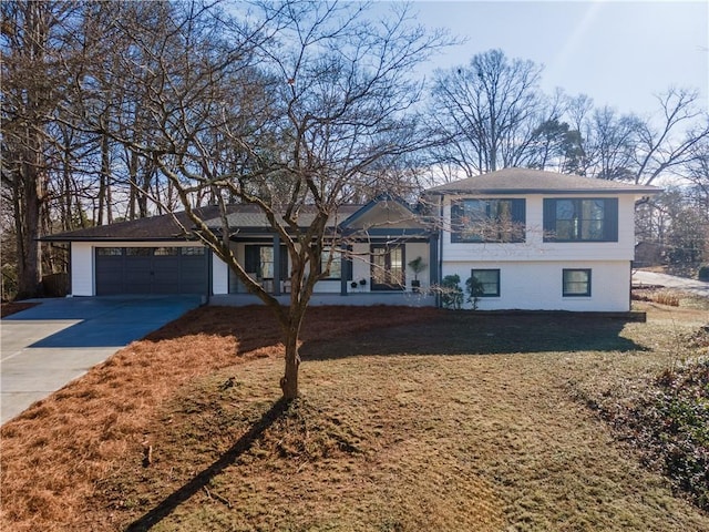 tri-level home with covered porch, a garage, and a front lawn