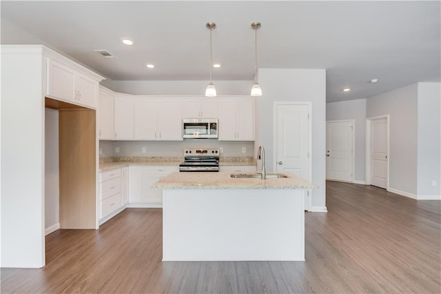 kitchen with a kitchen island with sink, sink, decorative light fixtures, white cabinets, and stainless steel electric range