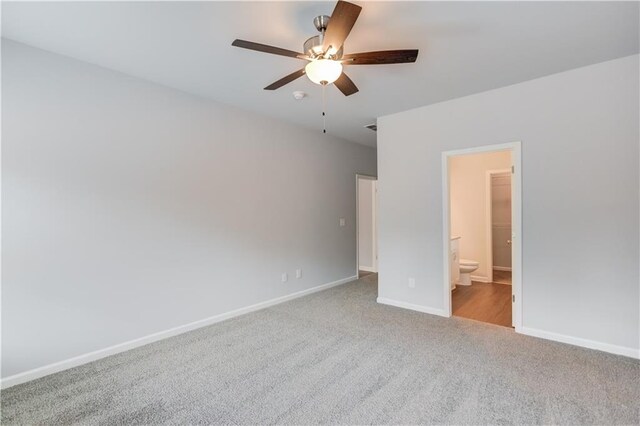 unfurnished bedroom featuring light carpet, connected bathroom, and ceiling fan