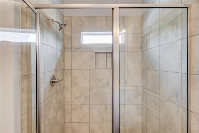 bathroom with a shower with door