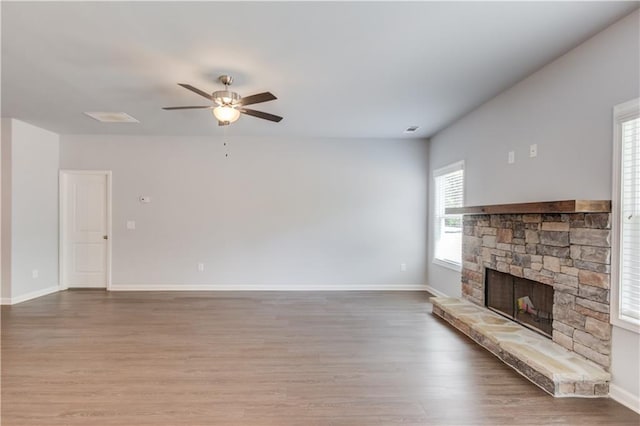 unfurnished living room with ceiling fan, wood-type flooring, and a fireplace